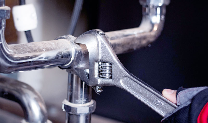 Image d'un plombier qui répare Mortier Sanitaire Genève